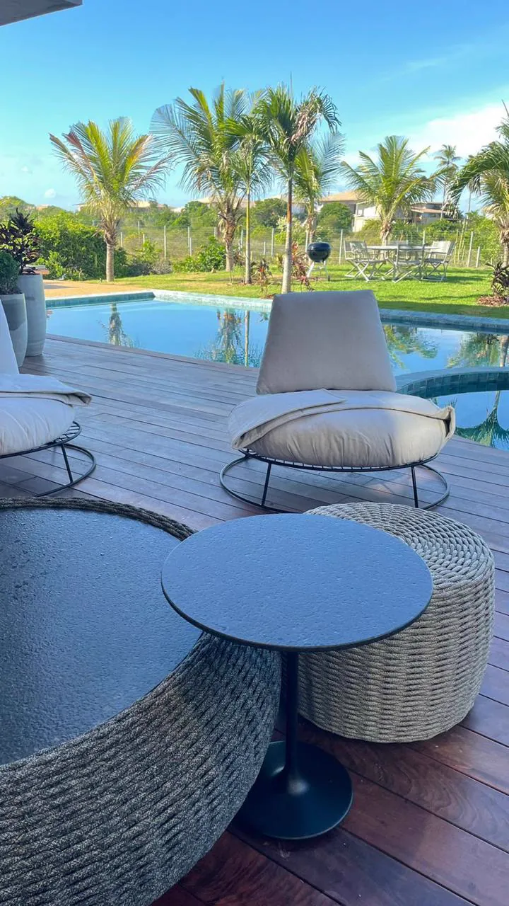 Deck com poltronas de descanso à beira da piscina