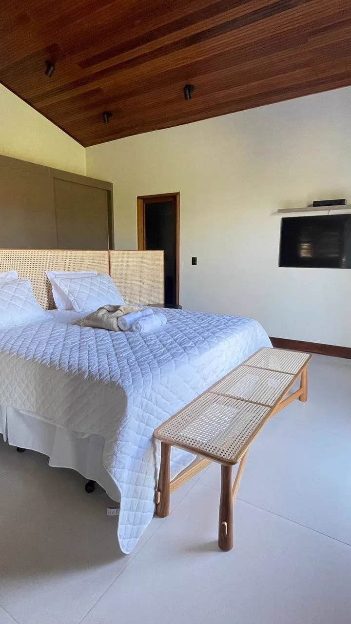 Suíte ampla com cama de casal e TV