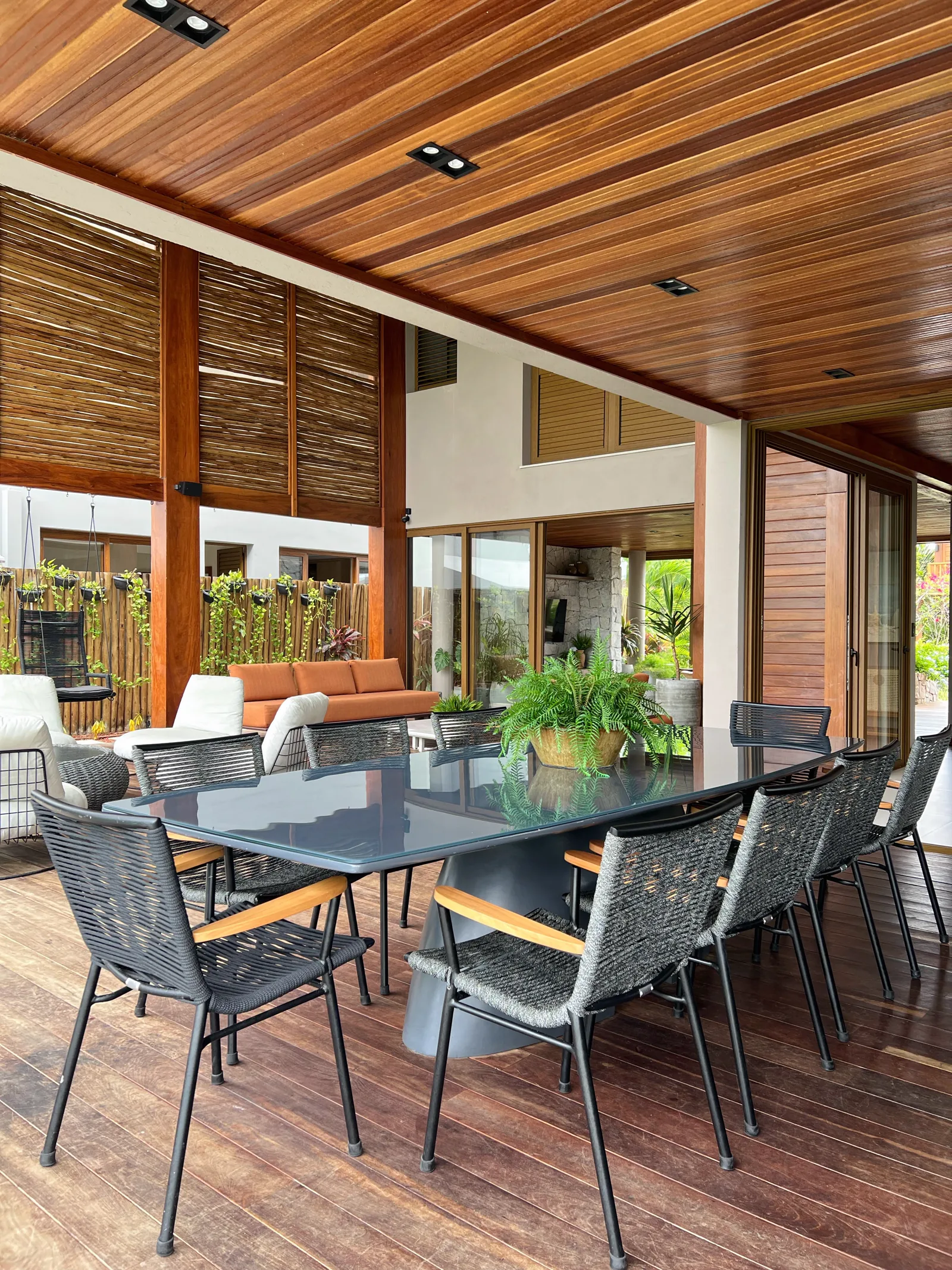 Varanda gourmet coberta com mesa de jantar e estar, aberta para o deck