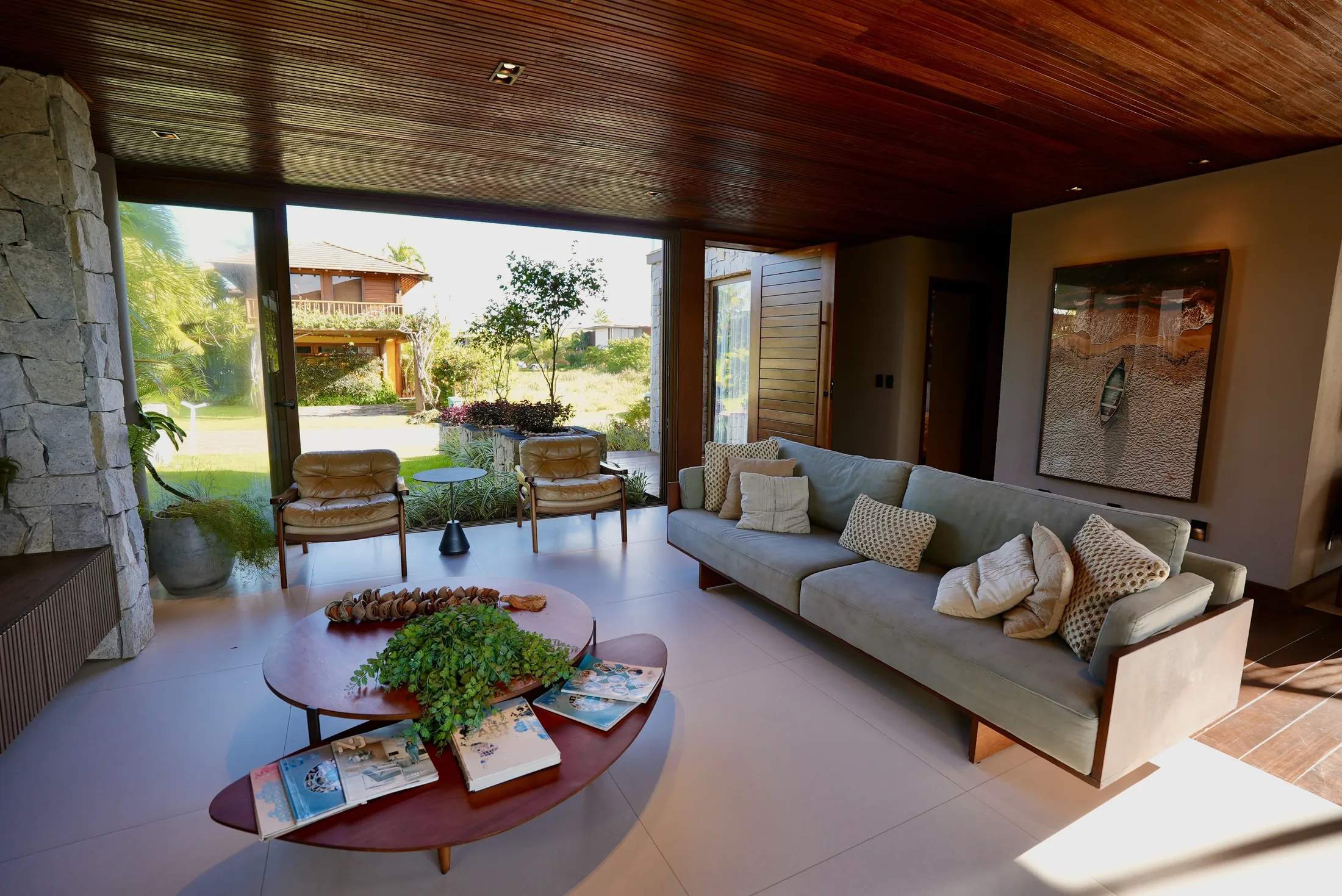 Living amplo com sofá integrado, mesa de centro e janela para o jardim