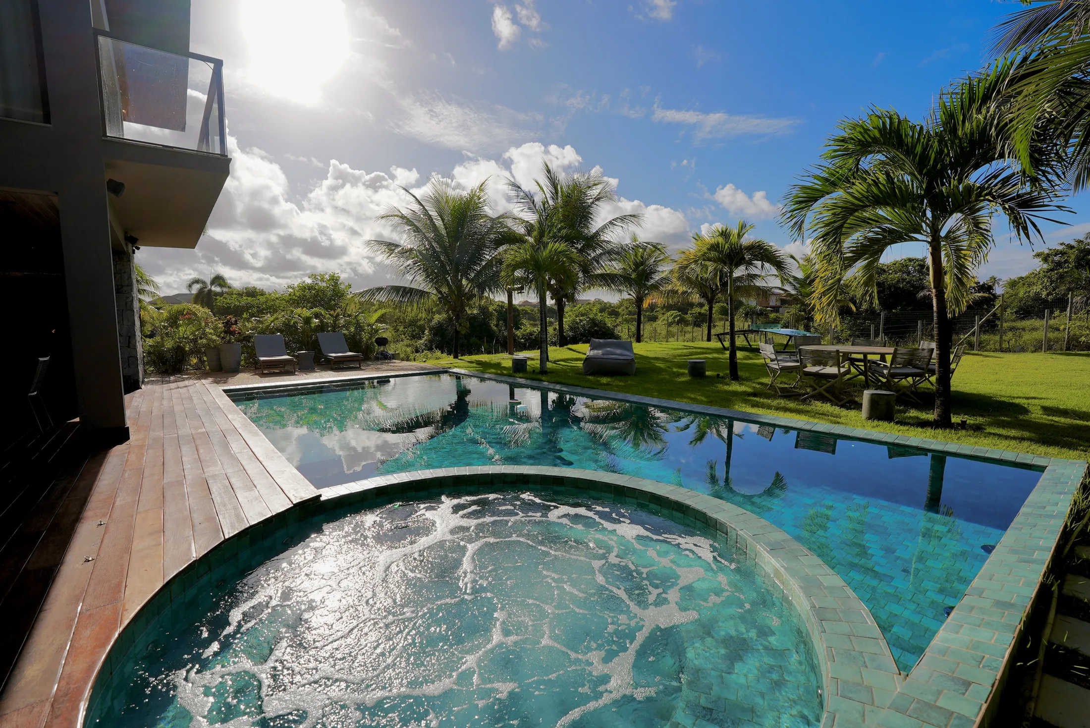 Jacuzzi com jatos e a piscina de borda infinita, com o jardim ao fundo
