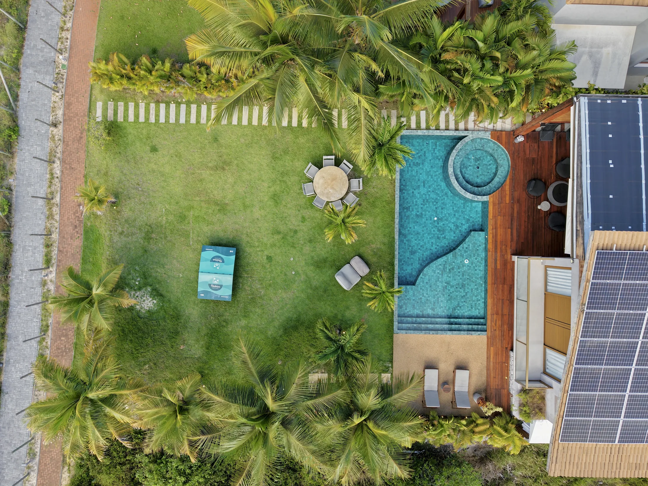 Vista aérea de cima do quintal, com a piscina e o jardim da casa